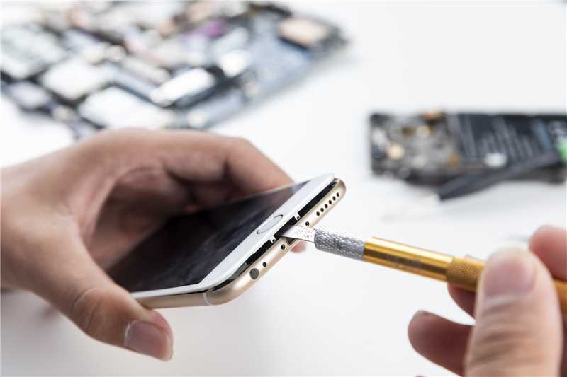 Expert phone repair technician at SJD Tech carefully repairing iPhone screen with professional tools in Ocean Grove workshop